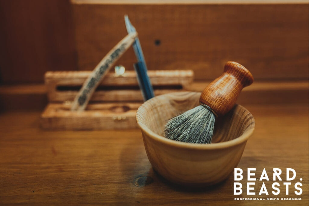 This image beautifully captures a high-quality shaving brush resting in a bamboo shaving bowl, showcasing the essentials of a traditional wet shaving routine. If you're wondering how to clean a shaving brush, maintaining tools like these is vital to ensure longevity and optimal performance. Regular cleaning not only keeps the bristles free of residue and buildup but also enhances the overall shaving experience. Proper care and storage of your shaving brush can preserve its soft texture and efficiency for years to come, making it a timeless addition to any grooming setup.