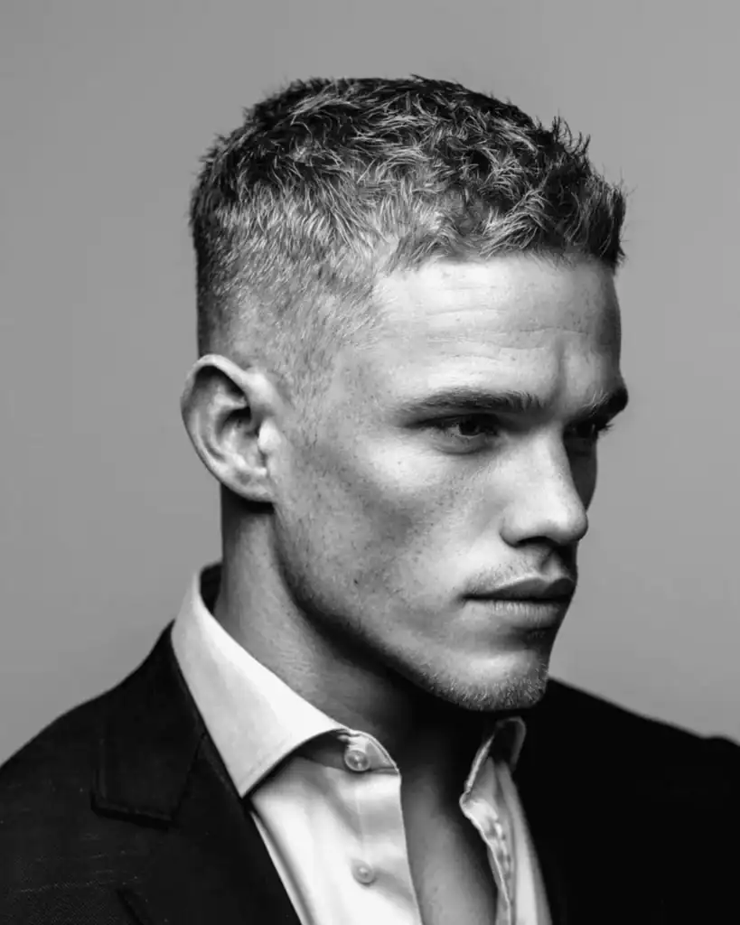 Side profile of a man with a short, textured crew cut and faded sides.