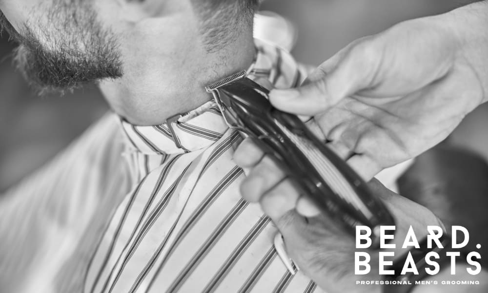 Hands of a barber using an electric trimmer on a man's neck, representing the professional guidance and communication crucial for getting the perfect haircut.