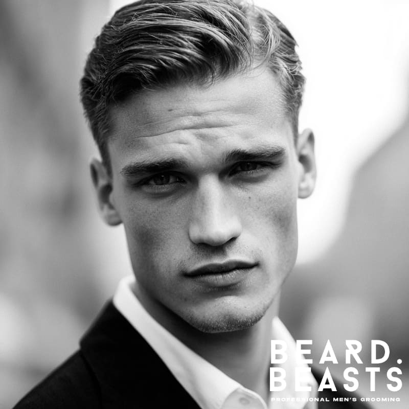 Black and white portrait of a man with a classic slicked side part haircut, a polished and timeless style for men with square face shapes.