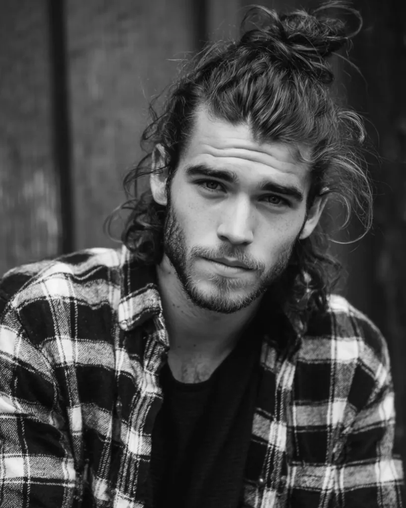 half-up half-down man bun hairstyle with hair left down at the sides, front view