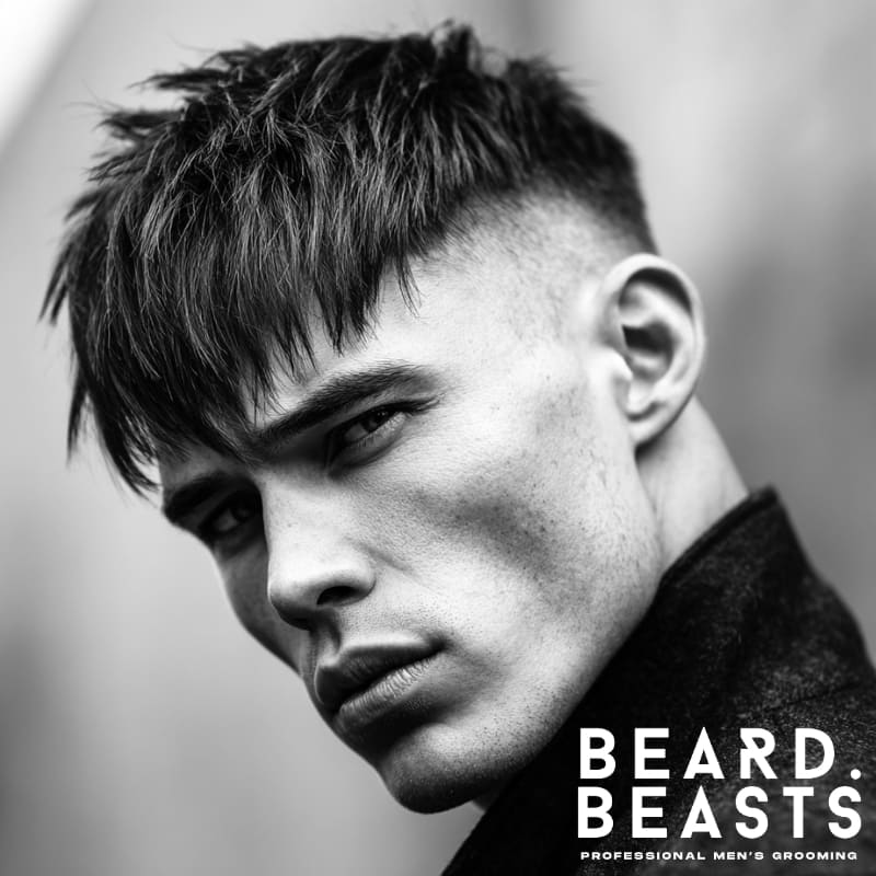 A stylish high fade long fringe haircut, showcasing a sharp fade on the sides with a longer, textured fringe on top. This modern men’s hairstyle offers volume, definition, and a bold contrast between the faded sides and the voluminous top, making it a popular choice for those seeking an edgy, fashionable look.