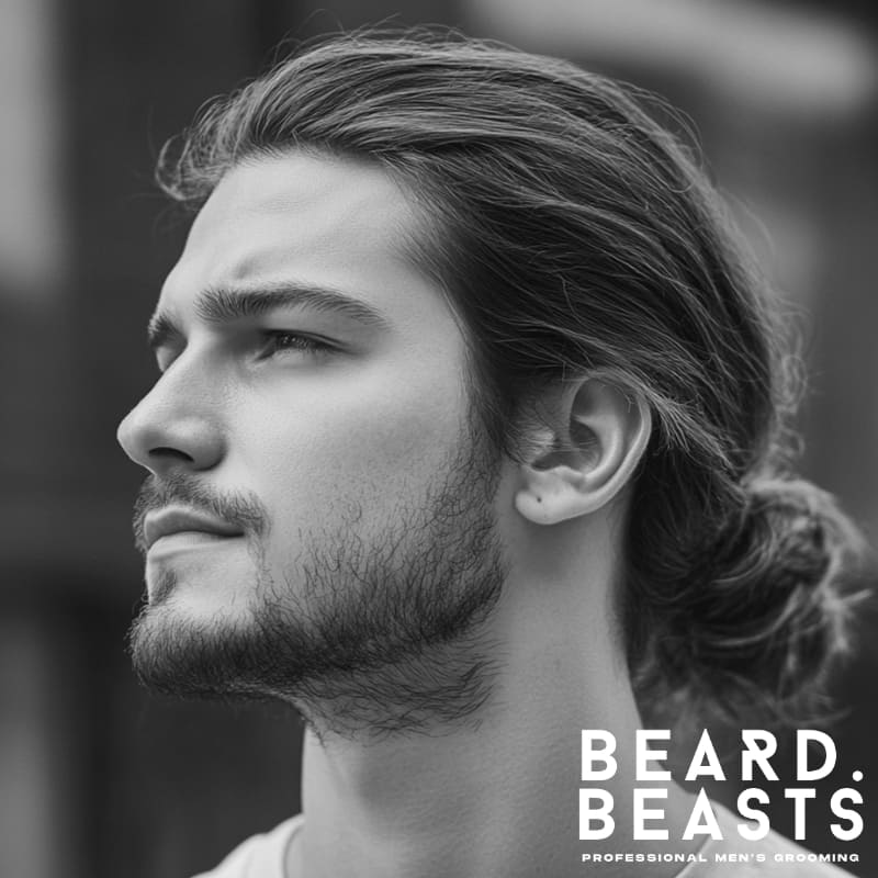 Side view of a man with a low man bun and natural long hair, styled with a clean, relaxed finish—perfect for a casual men’s hairstyle in 2025.