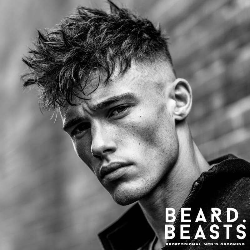 Man with a messy textured top and faded short sides, showcasing a modern short on sides, long on top haircut that delivers volume, edge, and a rugged style.