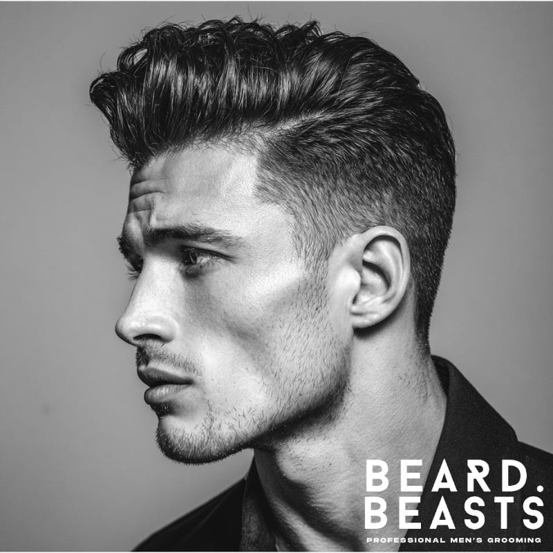 A stylish example of men’s short on sides, long on top haircuts featuring a side part. The sides are faded short, with the longer hair on top neatly styled to one side, offering a clean, structured look. This hairstyle combines classic elegance with modern sharpness, ideal for a refined, polished appearance.