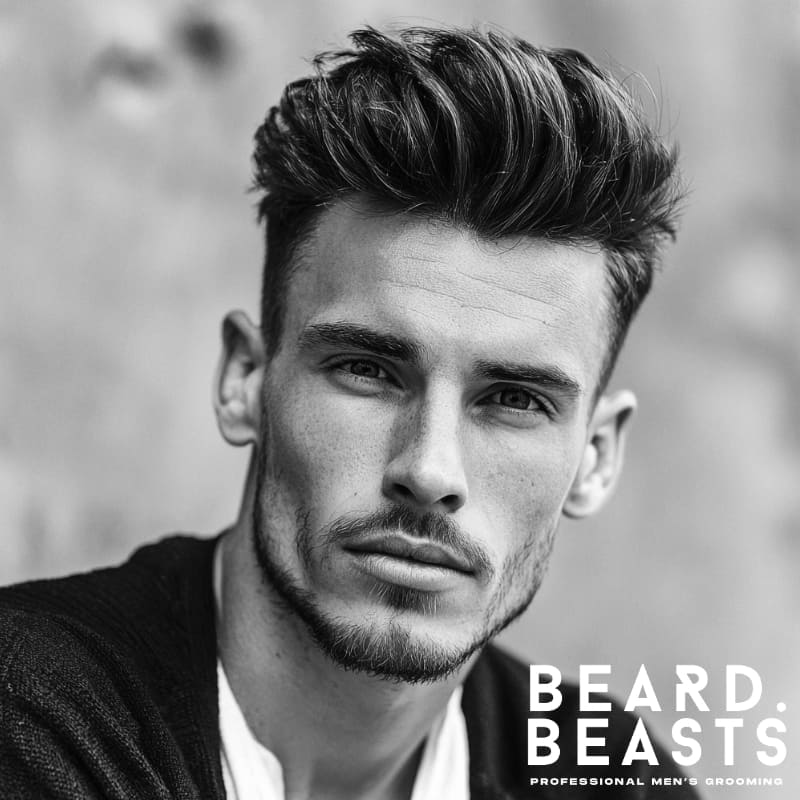 Black and white portrait of a man with a voluminous pompadour haircut, an incredibly flattering style for men with square face shapes.