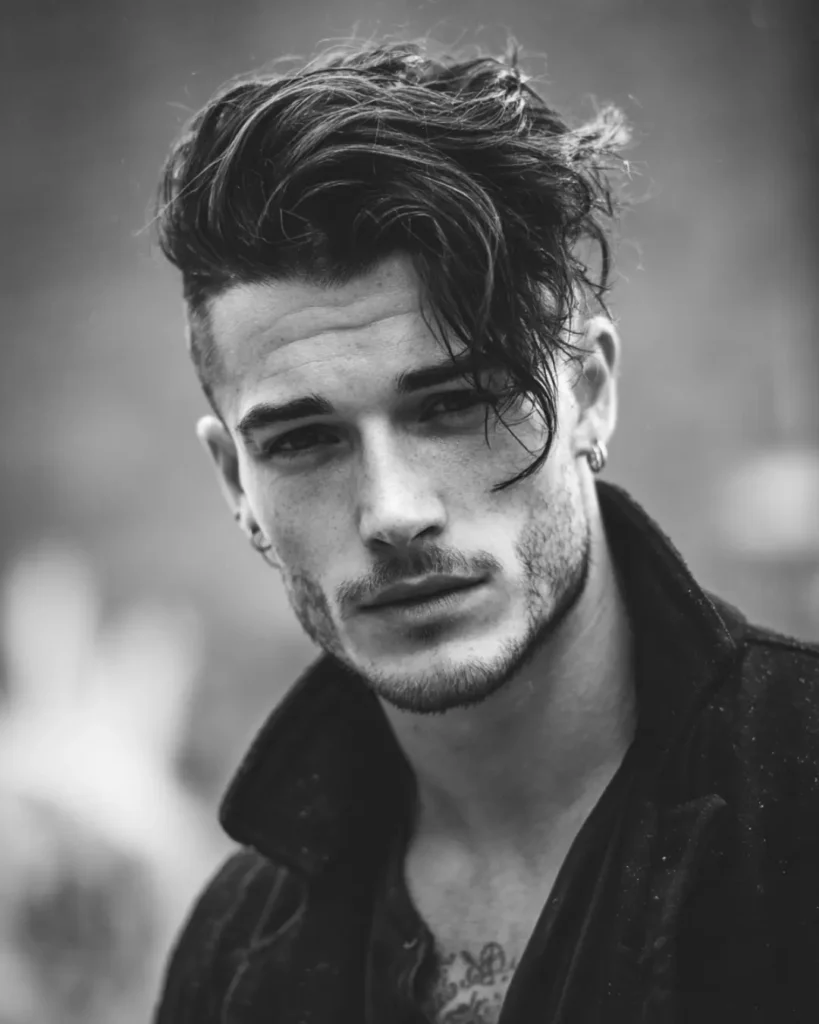 Side-swept undercut with longer hair swept across the top and short sides, showing a medium hairstyle option for men with round faces.