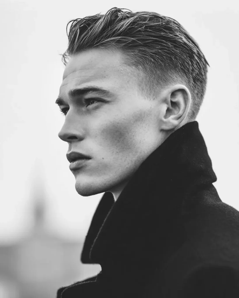 Slick back hairstyle with volume on top and shorter sides, showing a medium hairstyle option for men with round faces.