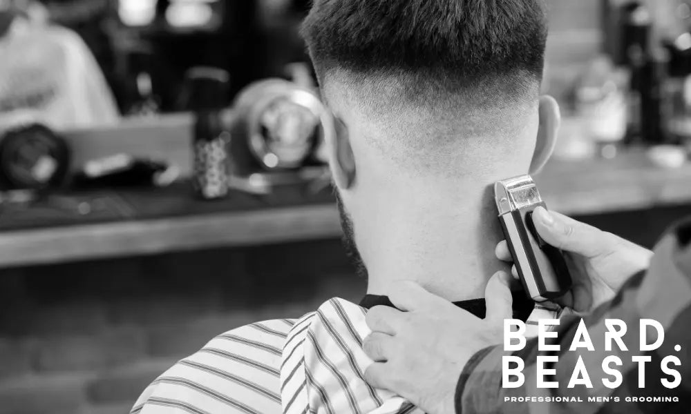 Barber trimming the back of a client’s hair during a fade haircut, showing a clean and precise fade on the sides.