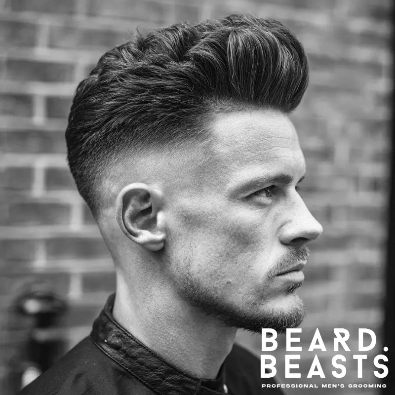 Classic skin fade pompadour with high fade on sides, voluminous top styled back for a sleek and polished look.