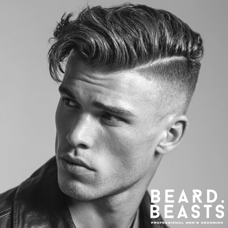 Man with a disconnected side part—razor-defined line, high volume top, and undercut sides with no blend.