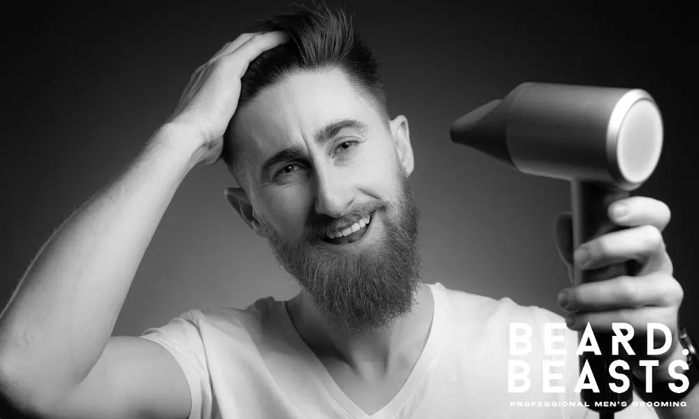Young man smiling while using a hair dryer to style a pompadour, adding volume and texture to the top for a sleek, voluminous look.