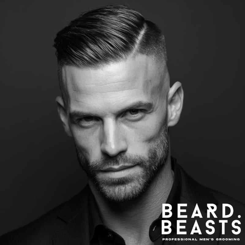 Skin fade comb-over hairstyle with sharp, clean sides and a sleek, styled top. A professional and polished example of skin fade hairstyles, offering a refined and sophisticated look.