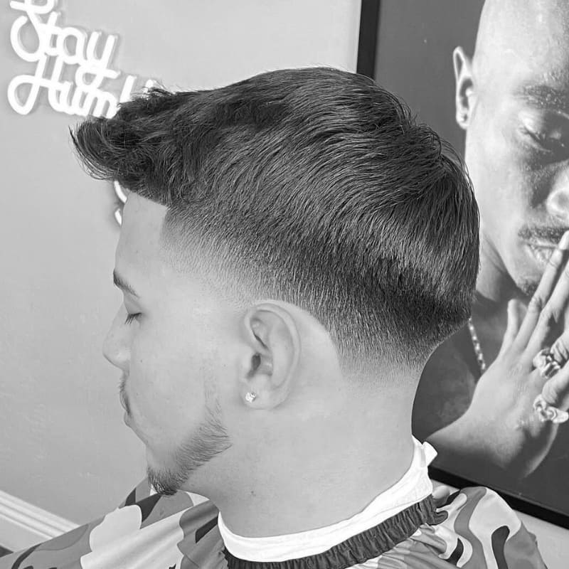 A clean taper hairstyle with a smooth transition from short hair on top to faded sides. The haircut blends modern style with precision, ideal for a refined, professional look.