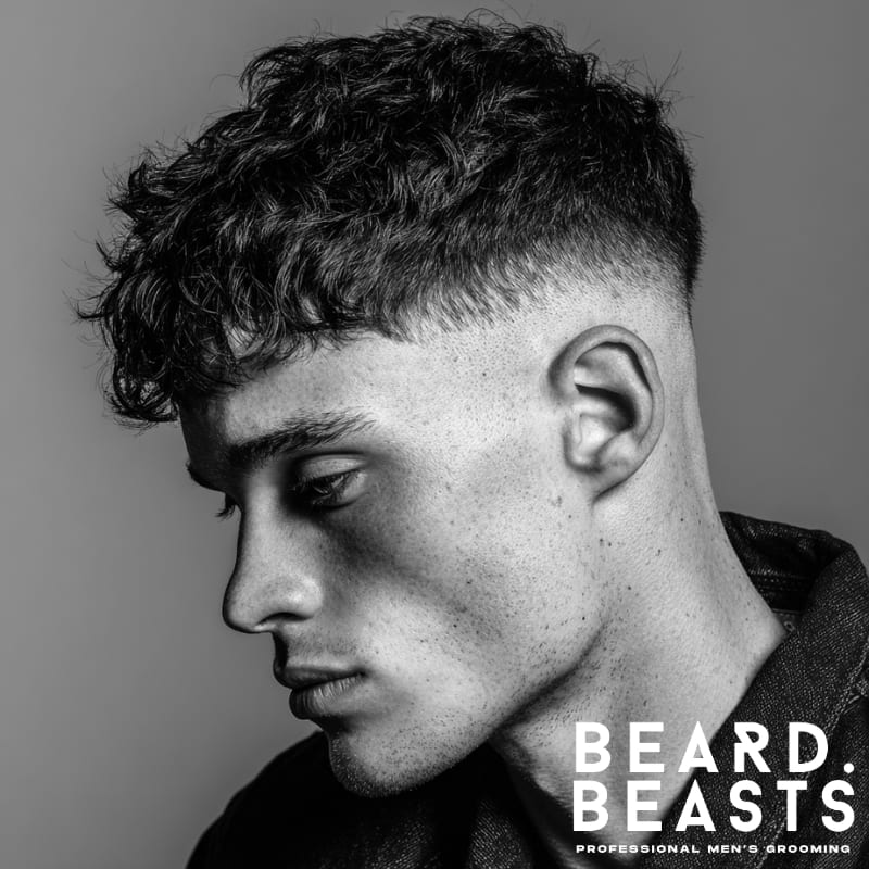 Skin fade with textured crop, featuring a clean fade on the sides and curly, textured hair on top for a bold and modern style.