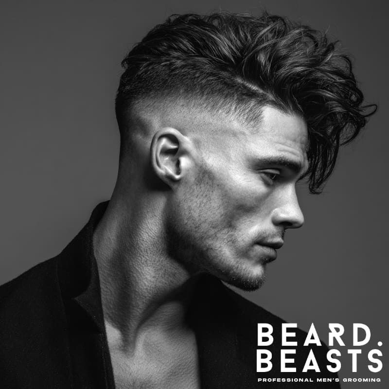 Skin fade with undercut and textured, messy hair on top, creating a bold, voluminous look. A modern and dynamic example of skin fade hairstyles with a perfect balance of sleekness and volume.