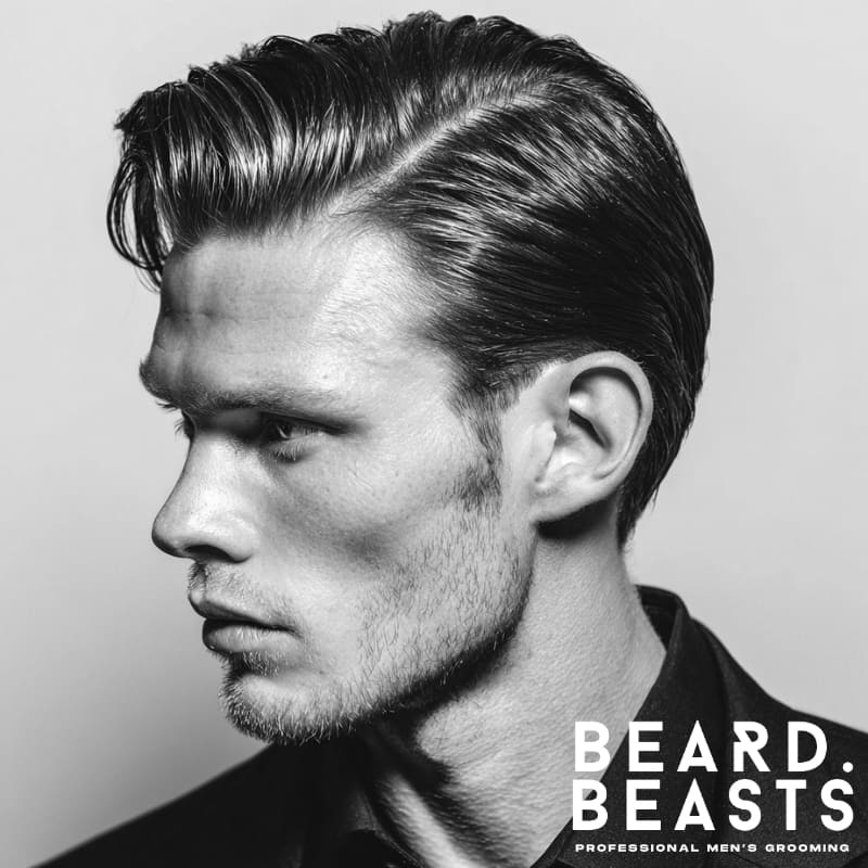 Man with a slick, high-shine side part—combed back top, glossy finish, and clean tapered sides.
