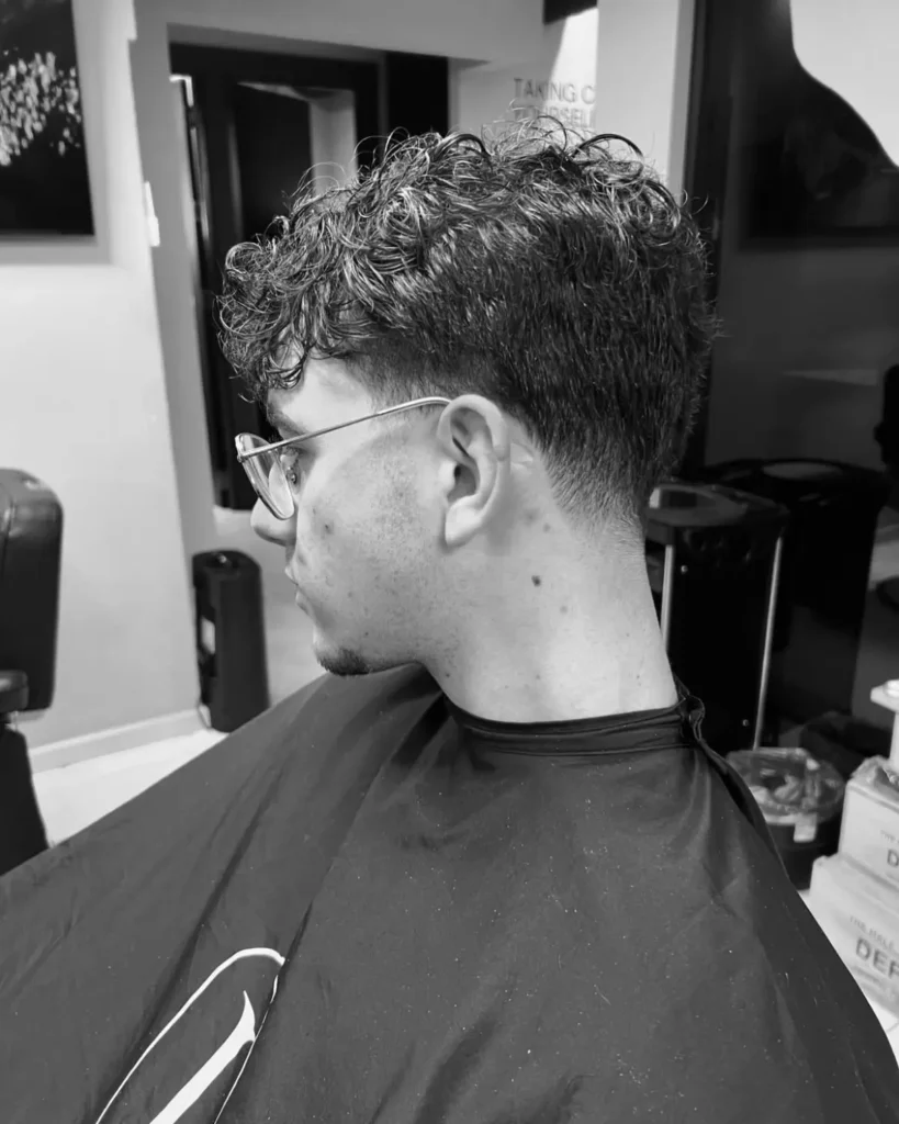 curly hair temp fade with low subtle blend at the neckline, side view
