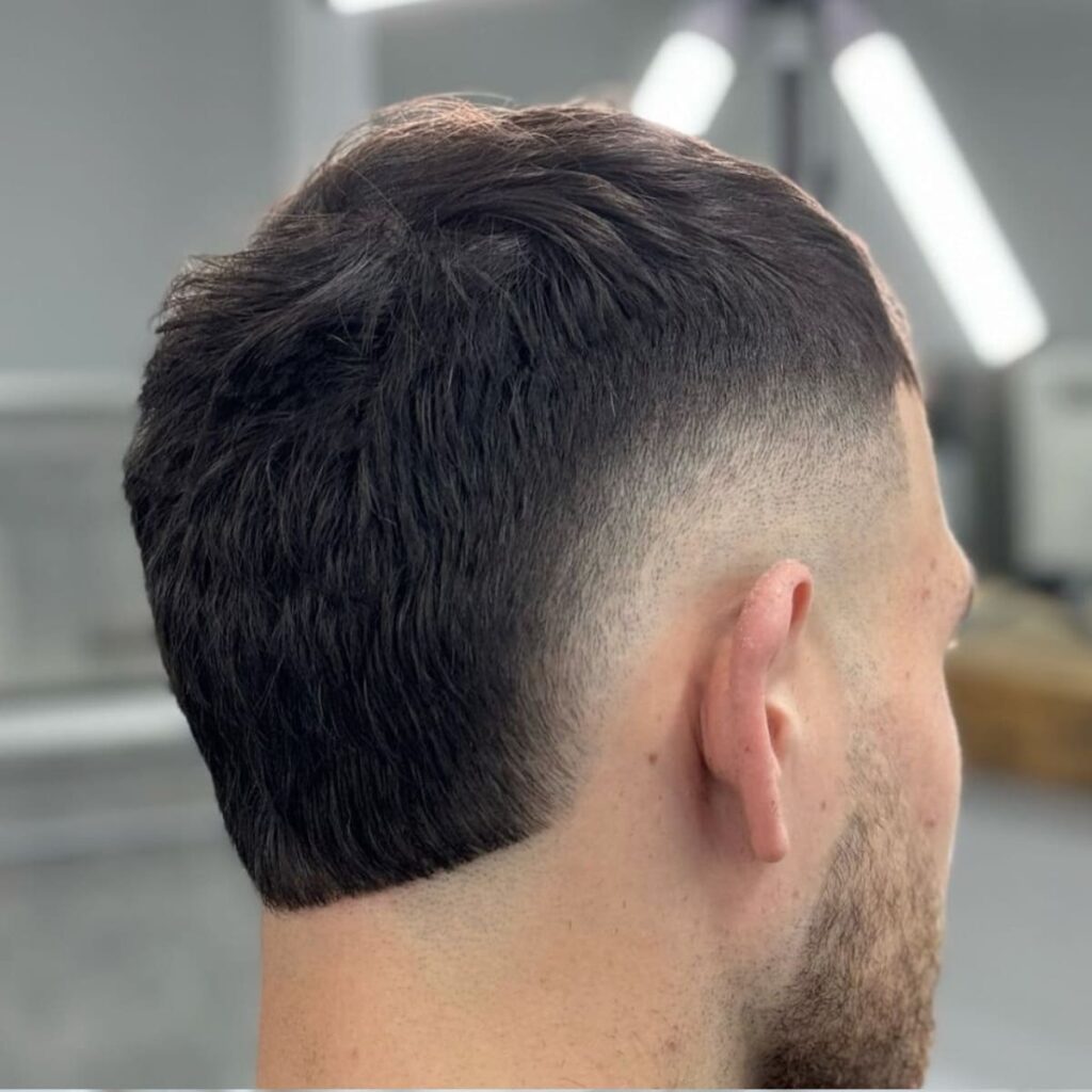 Short hair burst fade haircut with a clean rounded fade around the ears and sharp neckline, modern men’s hairstyle 2025.