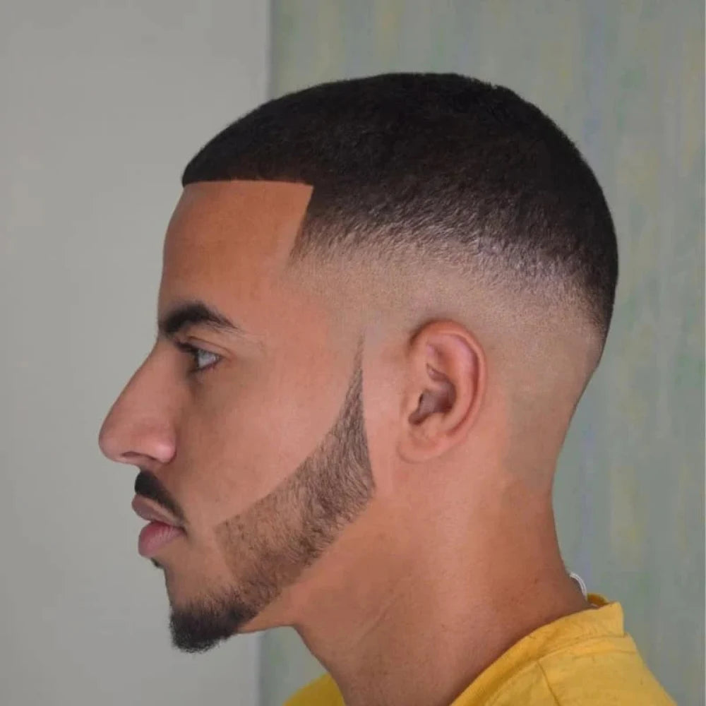Man with a mid bald fade buzz cut, featuring a sharp skin fade that drops to the scalp with defined edges for a clean, minimal look.