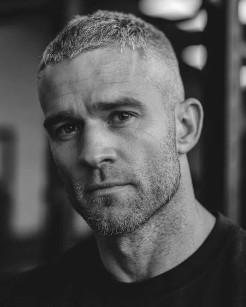 men's crew cut athletic hairstyle with grey hair and short textured top in gym setting