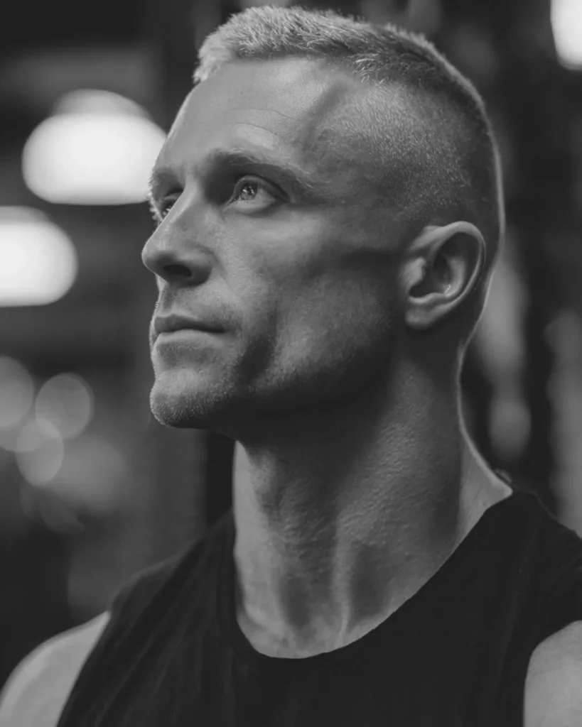 crew cut haircut on a bodybuilder with short textured top and fade, side profile in gym