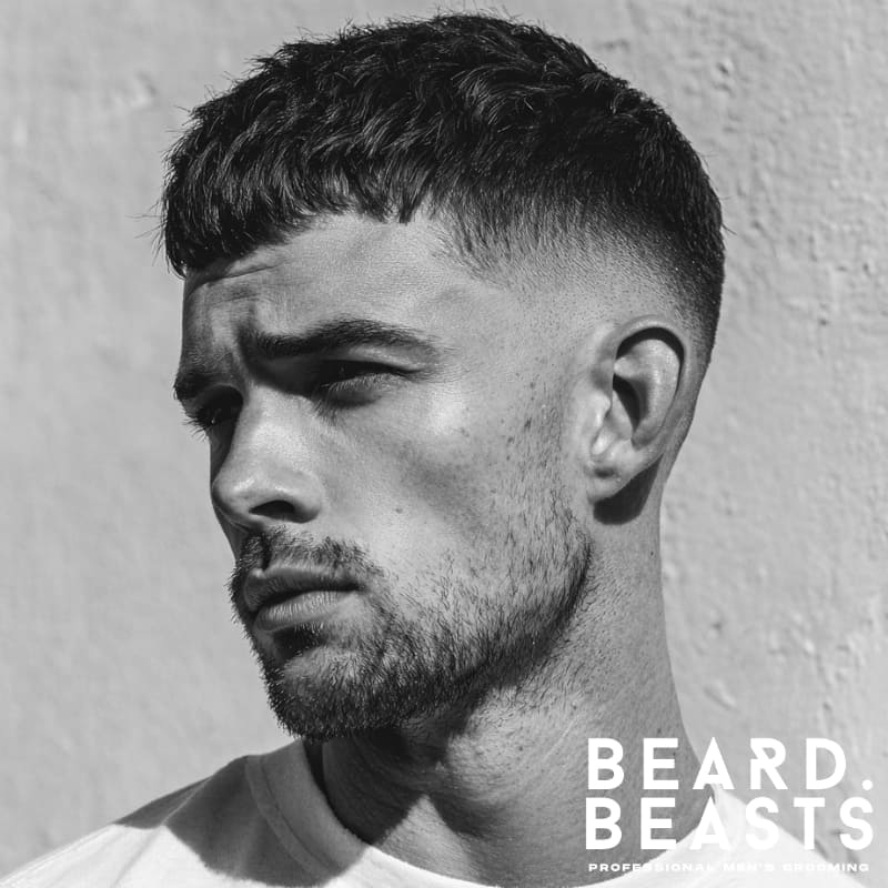 High drop fade French crop with a clean fade and textured top, paired with a subtle beard for a sharp, modern look. Ideal for men seeking a versatile, low-maintenance yet bold hairstyle.