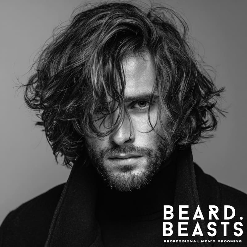 Young male model with a layered textured cut haircut for men, featuring natural waves and defined layers, perfect for textured haircuts for men seeking a bold, modern style.