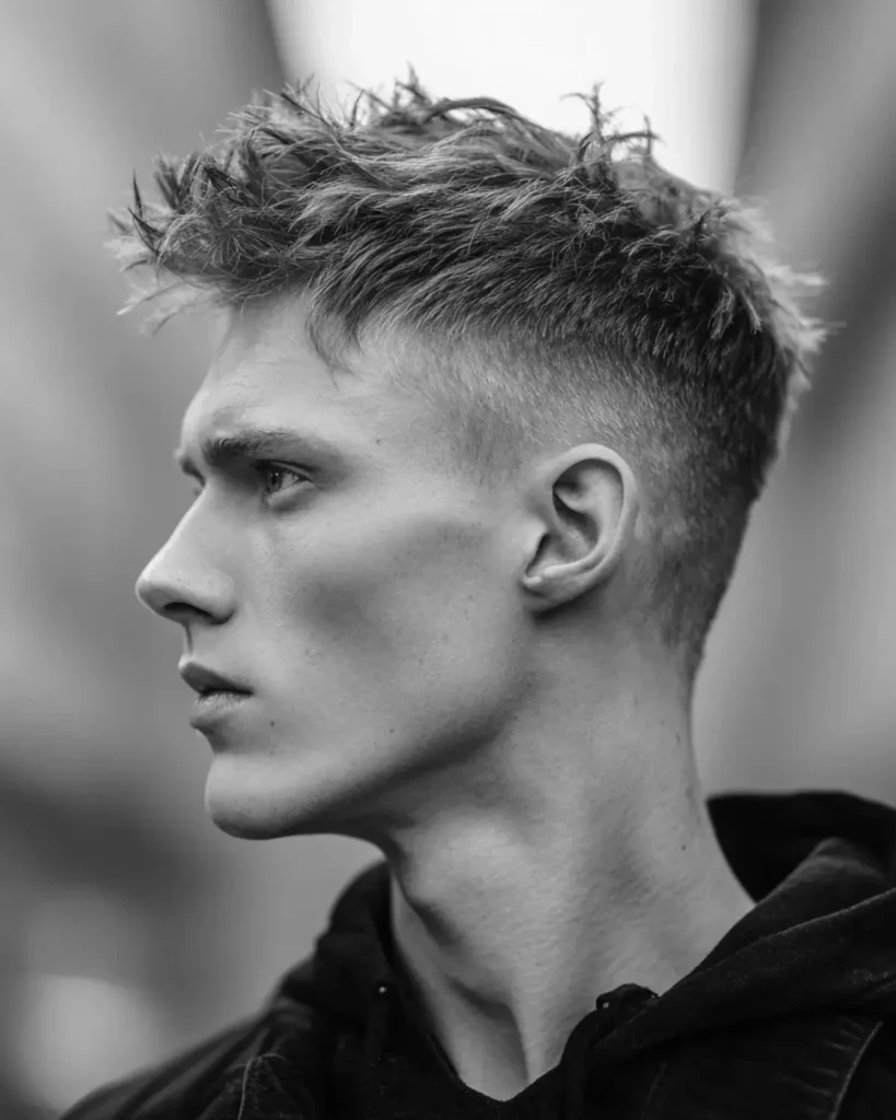 messy short textured quiff haircut with undone styling and mid fade, black and white side profile