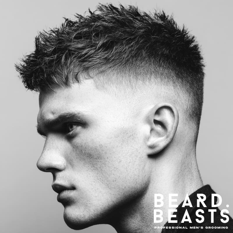 Short messy spiky hairstyle on a model, featuring a clean fade on the sides and textured spikes on top for a sharp, edgy look. The style maintains a natural, tousled appearance with defined spikes, perfect for a low-maintenance yet stylish finish.