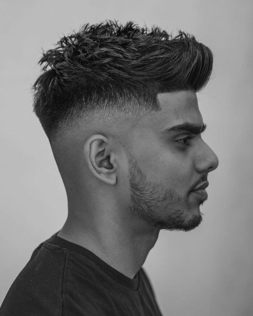 skin fade short textured quiff haircut with high contrast sides and defined front, side profile