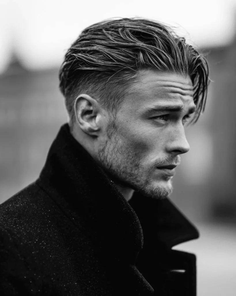 Slicked back undercut hairstyle for men with diamond face shape featuring clean sides and volume on top
