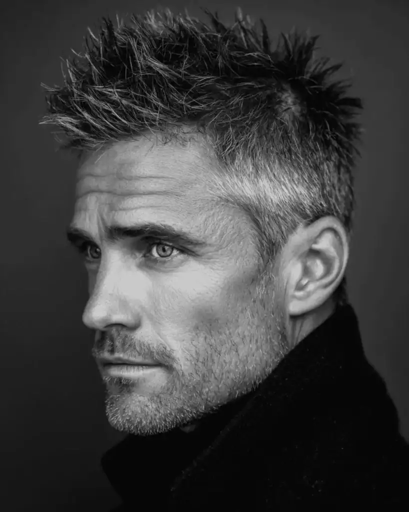 Black and white portrait of a man over 40 with a spiky texture cut, featuring short, uneven points and a matte finish.
