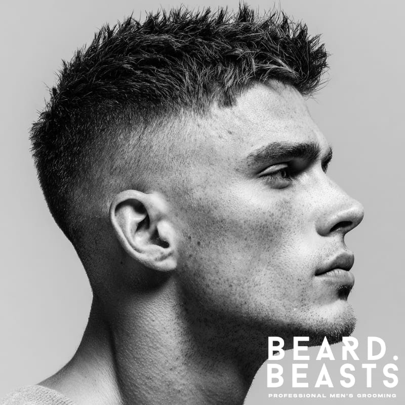 Young male model with a spiky textured look haircut for men, featuring short, layered spikes and a modern, bold style, perfect for textured haircuts for men.