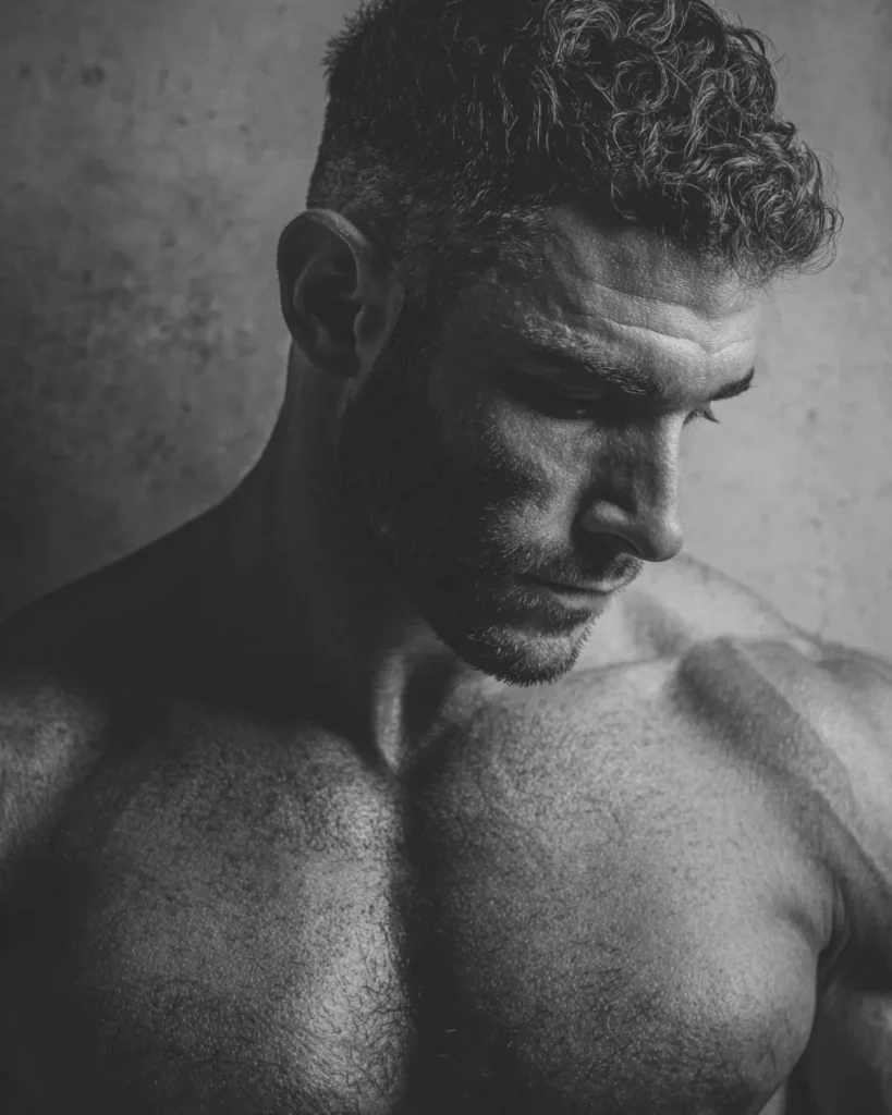 textured crop haircut on a bodybuilder with natural curl and fade, three-quarter view