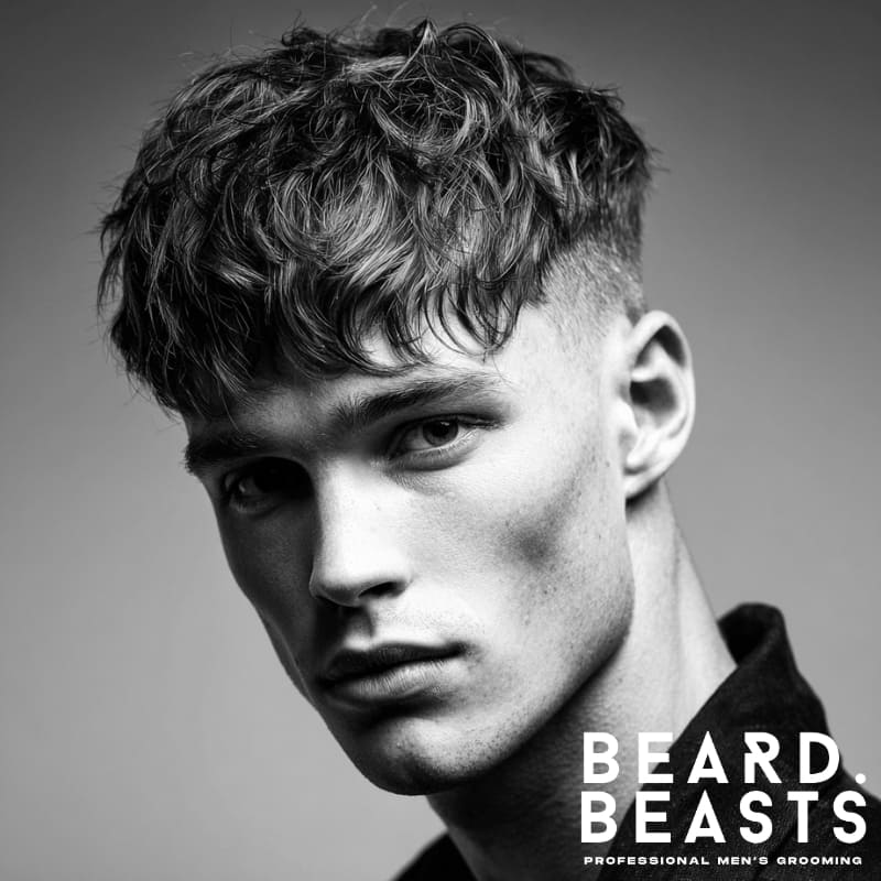 Young male model with a textured fringe haircut for men, showcasing a modern, youthful style and natural movement, perfect for textured haircuts for men.