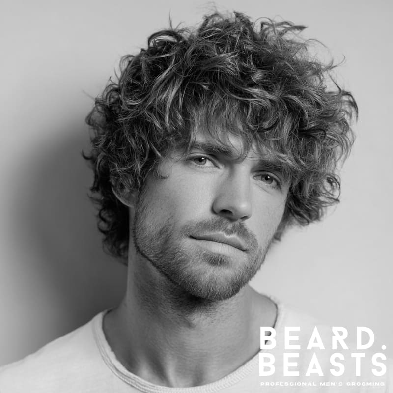 Young male model with a textured shaggy haircut for men, featuring natural volume and layers for a relaxed, modern look.