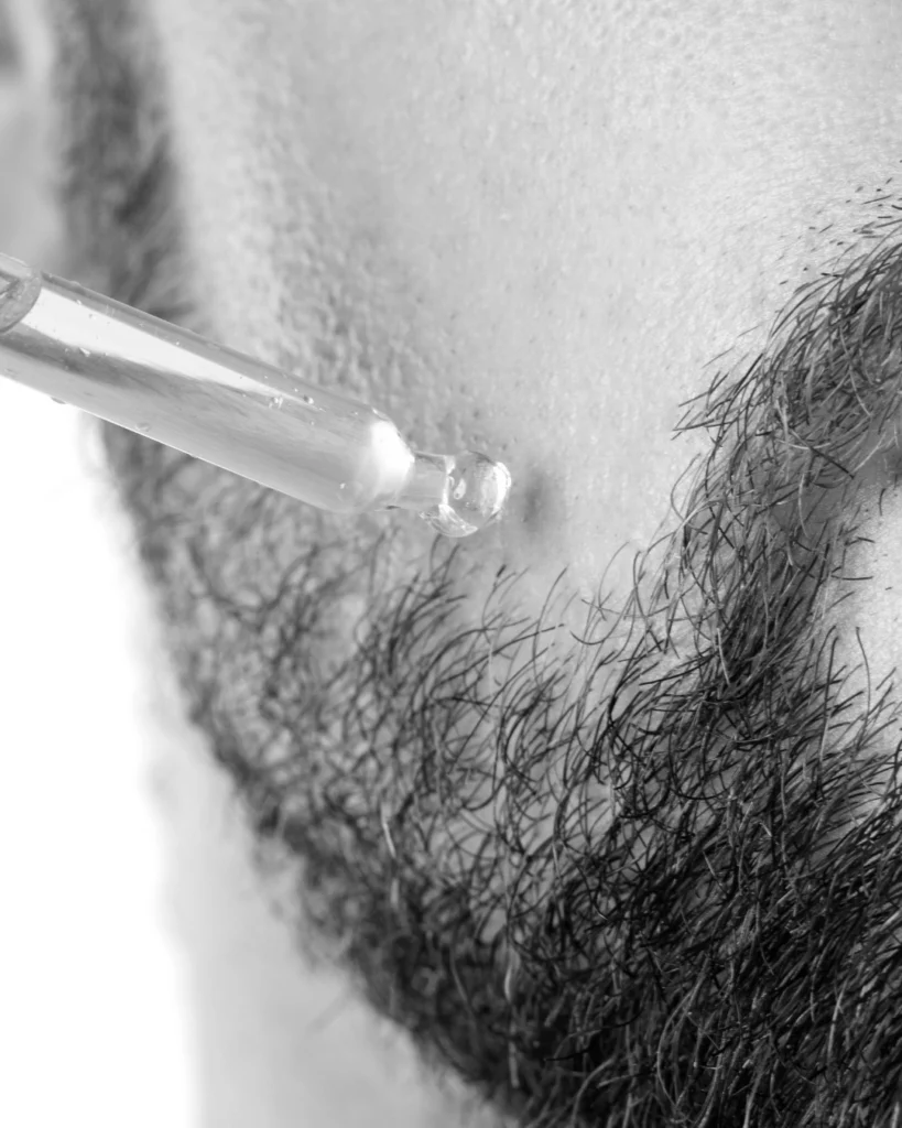 Man applying beard oil with a pipette, showing why beard growth products should be judged honestly and not treated as guaranteed fixes for a thicker beard.