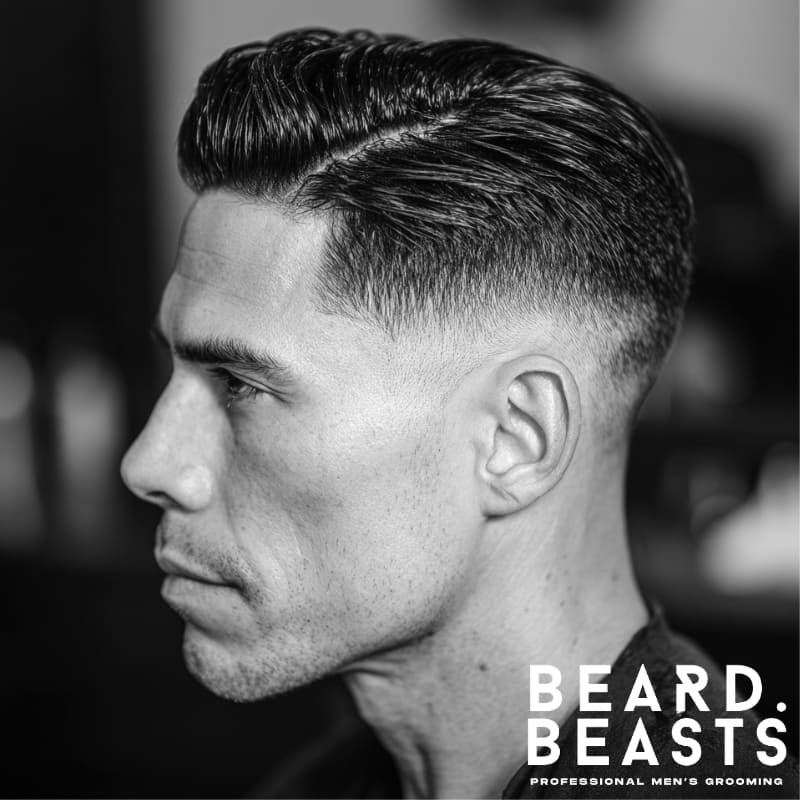 Man with a slicked back side part and mid fade—defined side part with a medium fade transition and high-shine finish for a balanced, structured look.