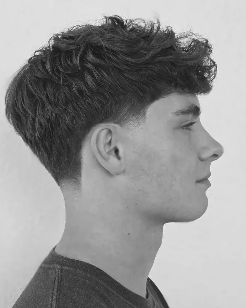 taper fade haircut with natural curl on top, side profile view