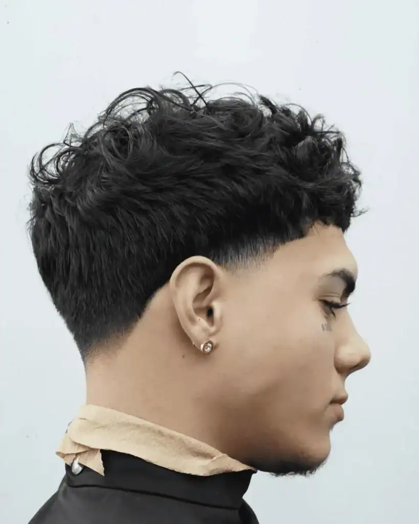 Side profile of a men’s taper fade haircut showing a natural arch around the ear with clean sideburn and neckline blending