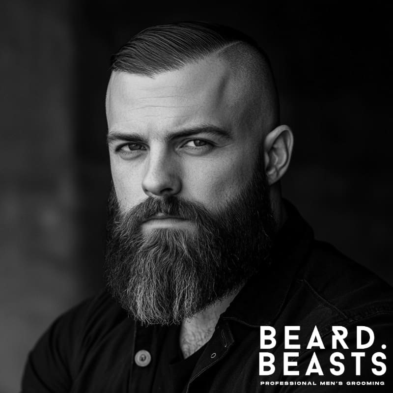 A confident man with a high and tight comb over, featuring a sharply defined side part and a sleek, side-swept top. The high fade transitions seamlessly into the skin, creating a bold contrast with the longer hair on top. His thick, well-groomed full beard adds to his strong, masculine presence, enhancing the rugged yet refined aesthetic. Dressed in a dark button-up jacket, he exudes confidence and power against a moody, blurred background. The