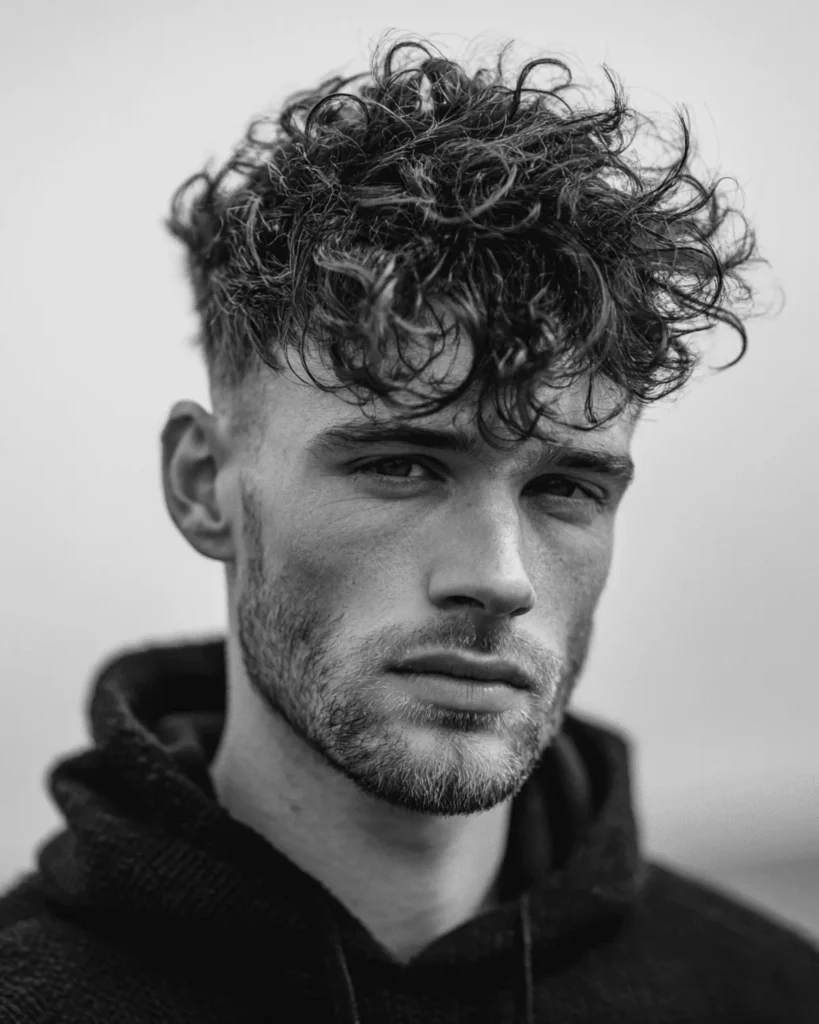 Curly messy textured crop with defined curls on top and short faded sides