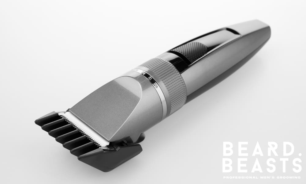 Close-up of a modern hair clipper with a sleek design, showcasing its fine comb attachment. The clipper features precision detailing, ideal for grooming and maintaining short hairstyles.