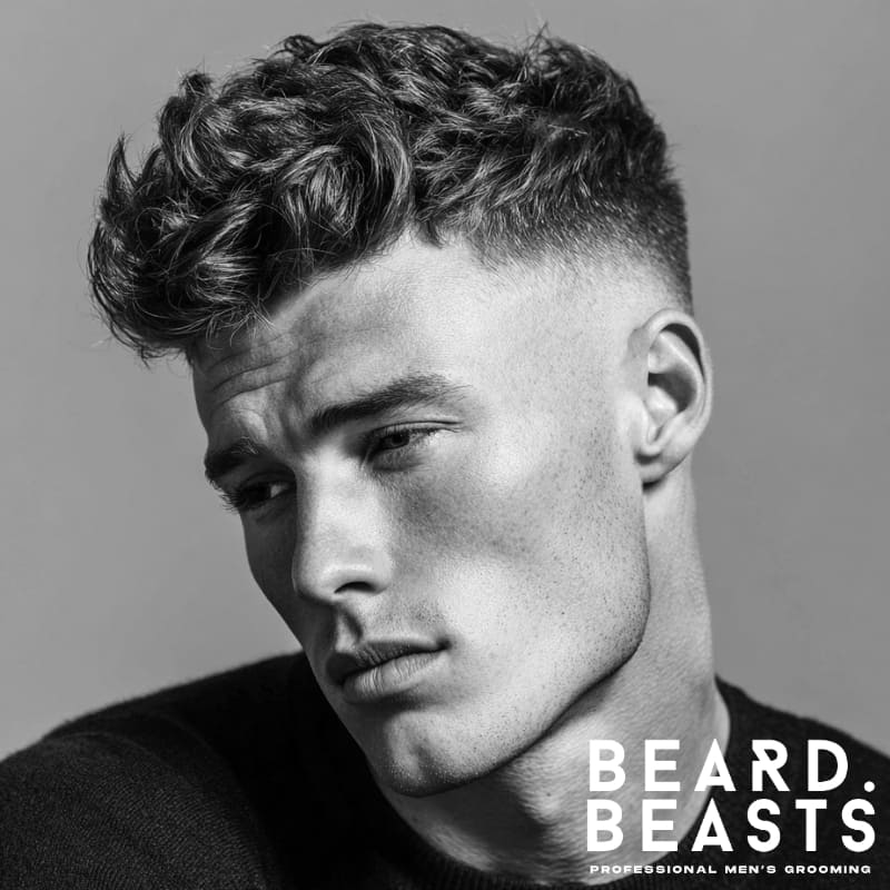 Men's short wavy quiff with a skin fade, offering volume and textured definition.
