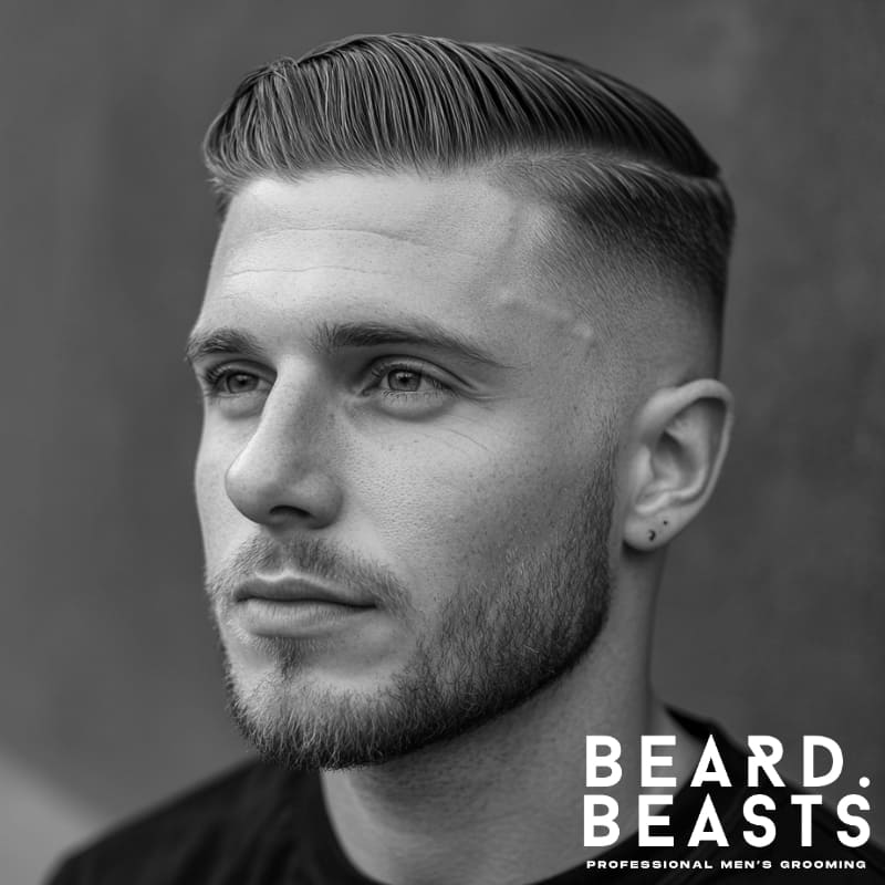 Man with a slick high drop fade comb over, featuring a smooth side part, tapered drop fade, and lightly styled shine for a polished finish.