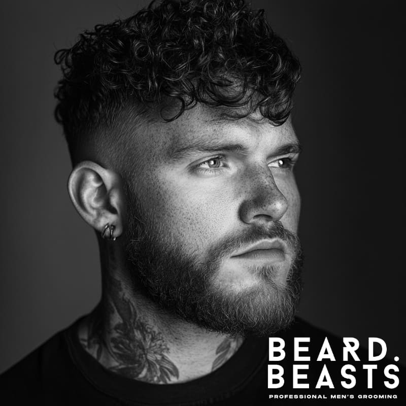 Curly textured fringe haircut with defined curls and a fade on the sides. A bold and stylish look that enhances natural curls while adding structure and volume.