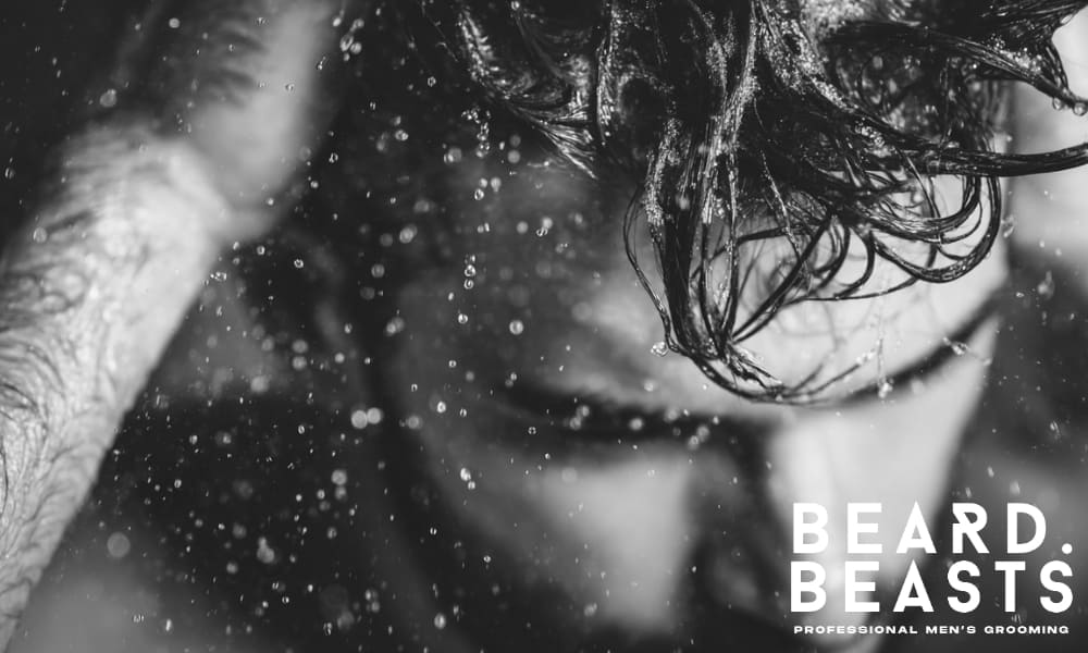 lose-up of a man washing his hair under water. The image captures the natural texture and movement of the hair, creating a fresh and dynamic look.