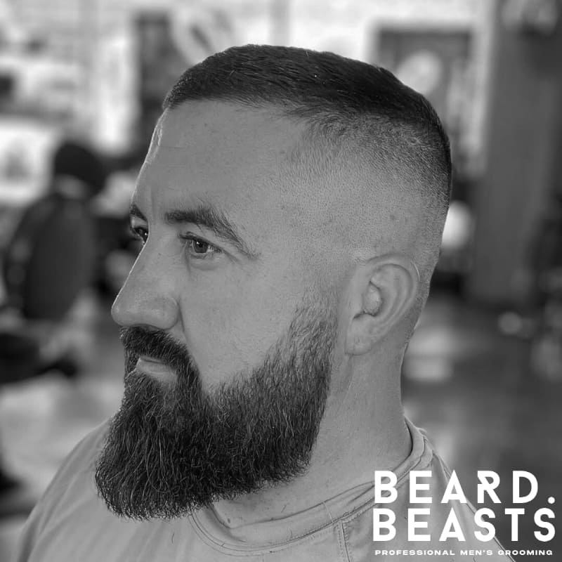 Man with a high and tight haircut and full beard—classic military-inspired look ideal for men’s short straight hairstyles.