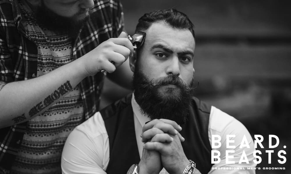 Bearded man receiving a precise haircut from a barber, emphasizing the importance of regular trims and structured grooming routines.